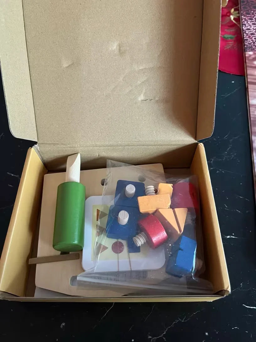 Reviewer photo of the set in its open box with the screwdriver, board, a card, and bag of screws