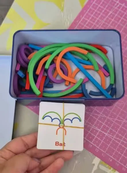 A hand holding the Bat card beside the open case of pieces.