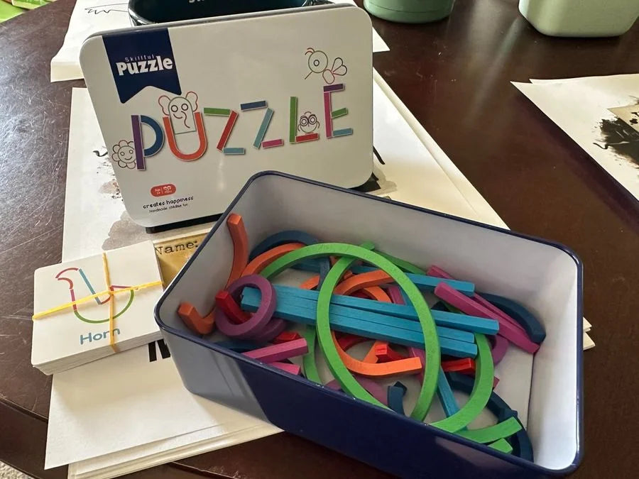 The metal case open, with pieces and cards spread on the table.