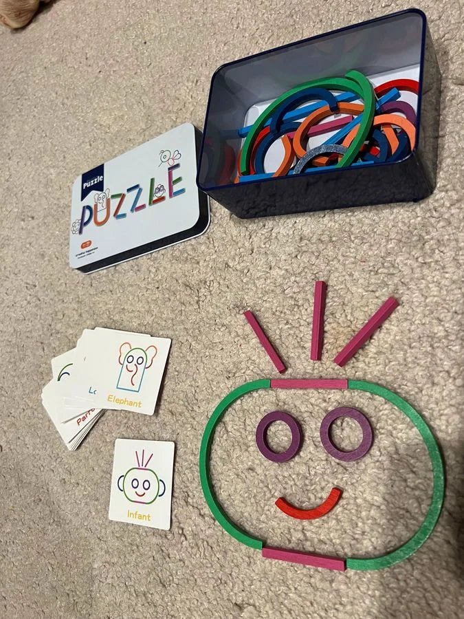 A face made from sticks and rings on a rug, next to the Infant card.