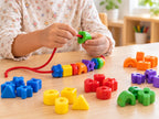 Child threading colourful lacing beads